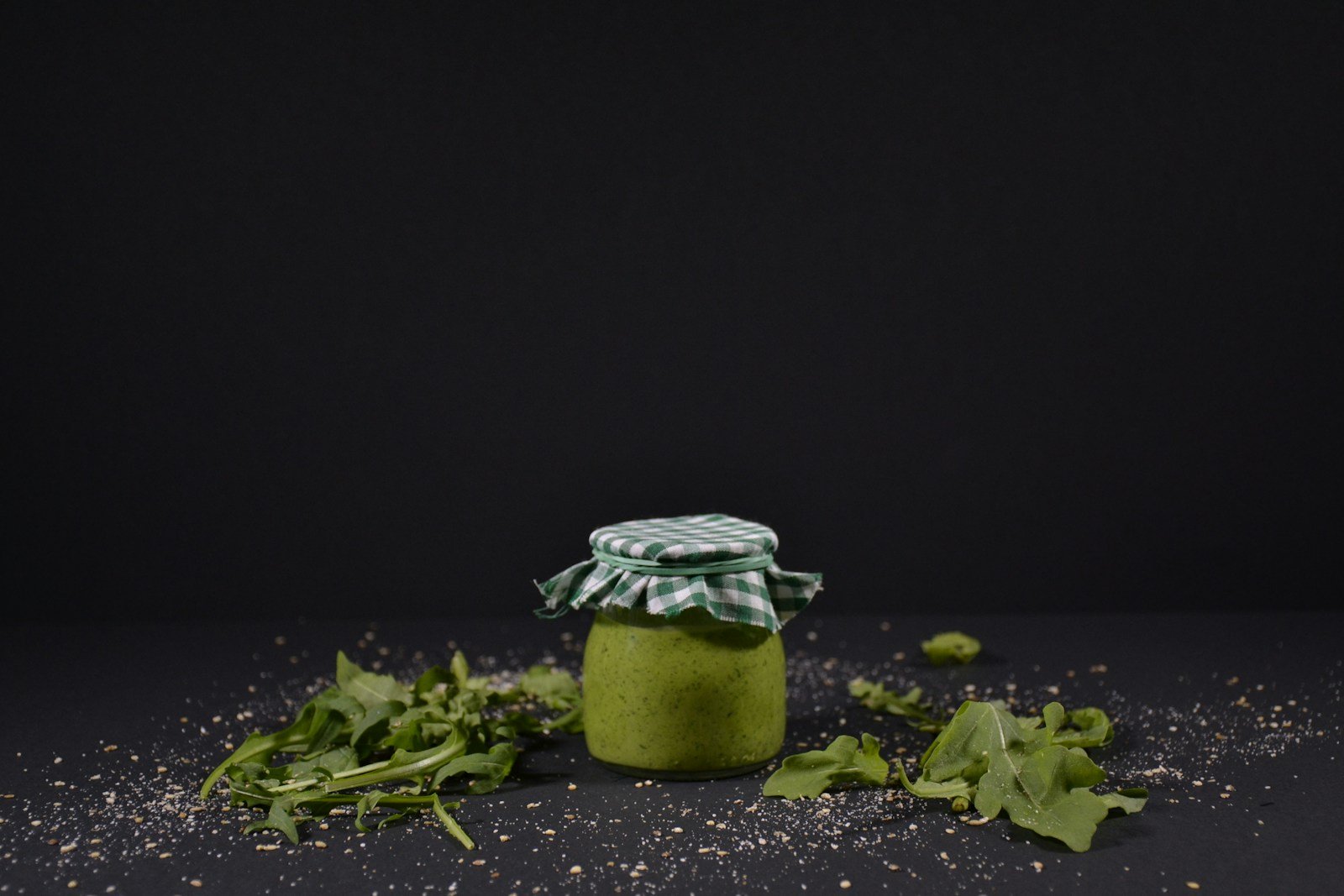 a jar filled with green stuff sitting on top of a table